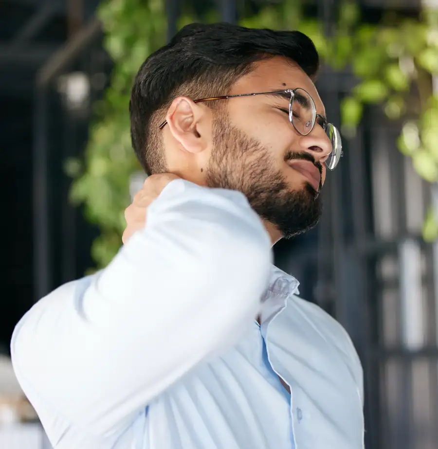 Man rubbing his sore neck after long hours at a desk